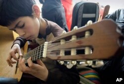 Seorang siswa Afghanistan berlatih bermain gitar di sebuah kelas di Institut Musik Nasional Afghanistan. (Foto: AP)