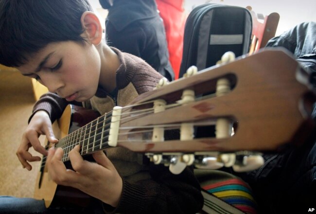 Seorang siswa Afghanistan berlatih bermain gitar di sebuah kelas di Institut Musik Nasional Afghanistan. (Foto: AP)