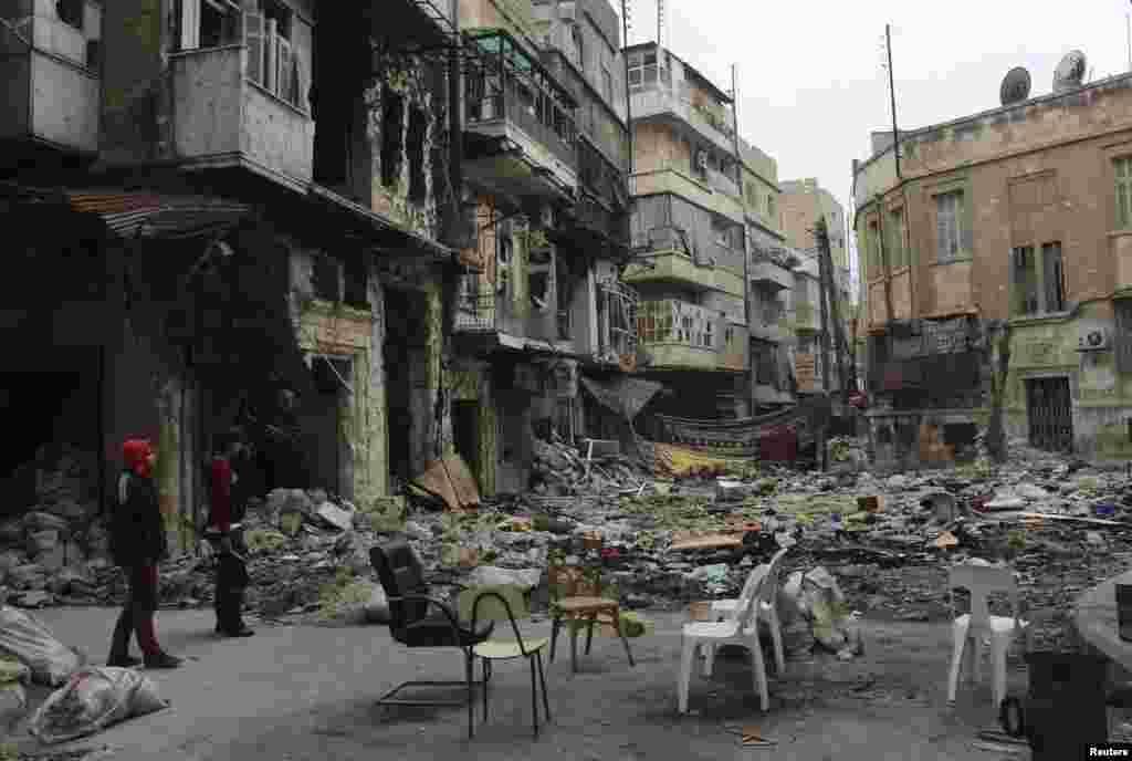 Free Syrian Army fighters stand along a deserted street filled with garbage and rubble in the old city of Aleppo, Jan. 22, 2014. 