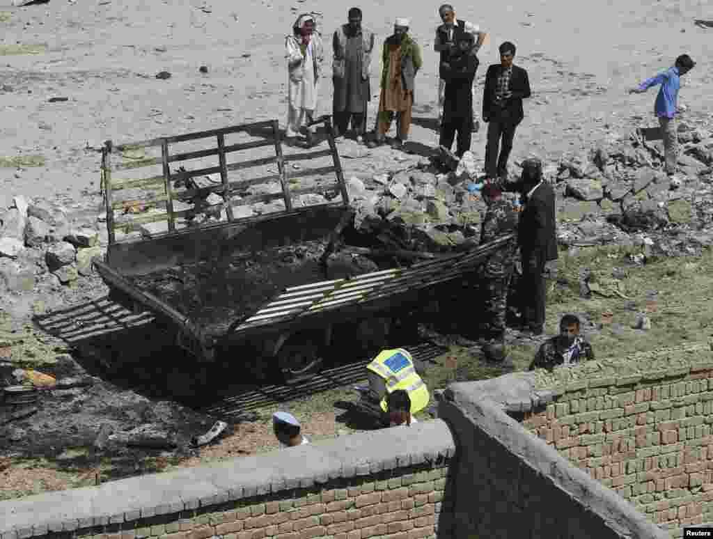 Afghan security personnel investigate the site of an attack in Kabul, June 10, 2013. 