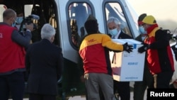 El presidente de Chile, Sebastián Piñera, observa mientras los trabajadores llevan el primer lote de la vacuna Pfizer-BioNTech COVID-19 a un helicóptero. Chile, jueves 24 de diciembre de 2020.