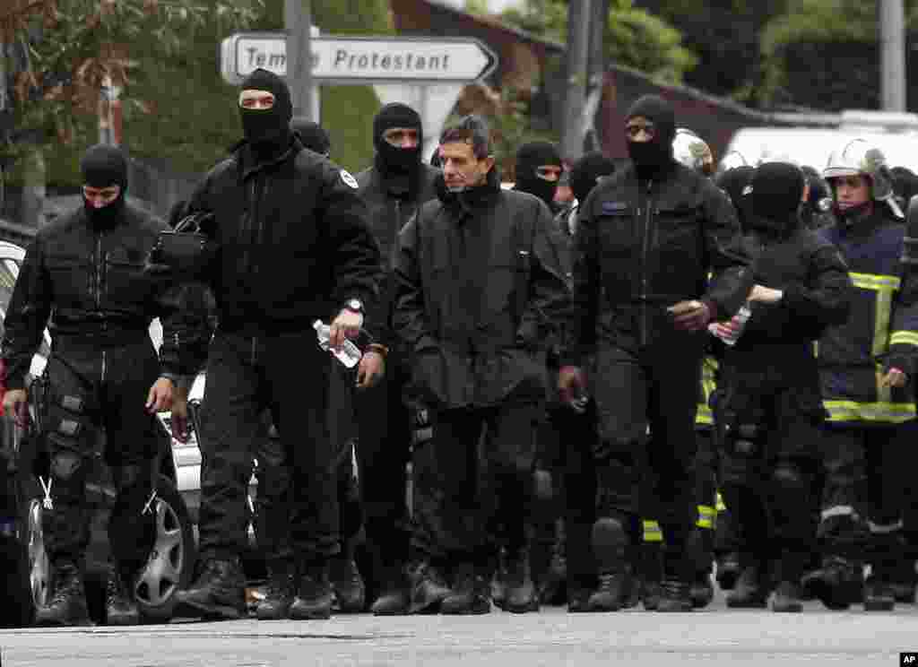 Masked French special unit policemen leave the scene after the assault to capture gunman Mohamed Merah during a raid on a building to arrest the suspect in Toulouse, March 22, 2012. (Reuters)