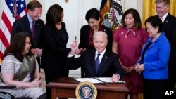 BidenPresident Joe Biden hands out a pen after signing the COVID-19 Hate Crimes Act, in the East Room of the White House, Thursday, May 20, 2021, in Washington. Clockwise from left, Sen. Tammy Duckworth, R-Ill., Sen. Richard Blumenthal, D-Conn., Vice Pres