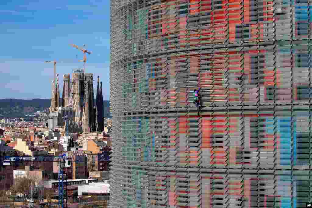 French urban climber, Alain Robert, known as Spiderman, scales the 144 meters (472 ft) of the Glories Tower in Barcelona, Spain. Spanish authorities briefly detained him after the stunt.