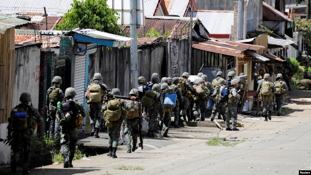 FILE - Philippine Marines advance their positions as more soldiers reinforce to fight the Maute group in Marawi City in southern Philippines May 29, 2017. 