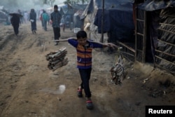 A Rohingya refugee boy carries firewood in the early morning at the Burma Para refugee camp near Cox's Bazar, Bangladesh