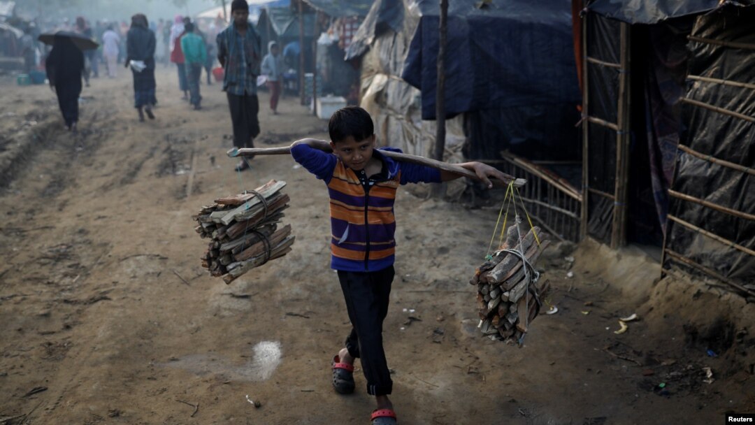 Seorang anak pengungsi Rohingya mengangkut kayu bakar di kamp "Burma Para" dekat Cox's Bazar, Bangladesh. Musim dingin telah tiba di sekitar kamp pengungsi dan mengancam para pengungsi akan menderita akibat kedinginan. 