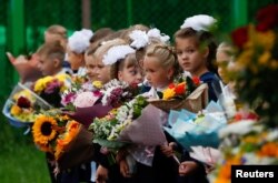 iswa kelas satu berkumpul menandai dimulainya tahun ajaran baru. Sekolah dibuka kembali setelah liburan musim panas dan lockdown karena wabah Covid-19, di Moskow, Rusia 1 September 2020. (Foto: Reuters)