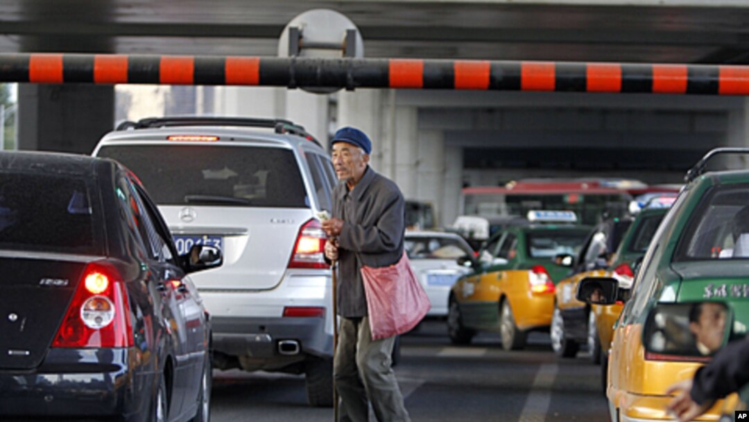 A Chinese beggar walks amongst traffic asking for a handout in Beijing, China. China's inflation rate edged lower in September, giving Chinese leaders leeway to stimulate the economy as U.S. and European growth slows, October 14, 2011.