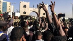 Para demonstran berpawai dengan membawa bendera nasional saat unjuk rasa di luar markas militer di ibu kota Sudan, Khartoum, 13 April 2019. Para pengunjuk rasa menuntut badan sipil untuk memimpin transisi ke demokrasi.