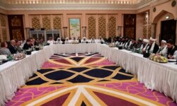 FILE - This Qatar Ministry of Foreign Affairs photo from Feb. 25, 2019, shows U.S. and Taliban representatives meeting in Doha to discuss ways to end the Afghan war.