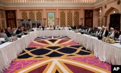 FILE - This Qatar Ministry of Foreign Affairs photo from Feb. 25, 2019, shows U.S. and Taliban representatives meeting in Doha to discuss ways to end the Afghan war.