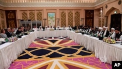 FILE - This Qatar Ministry of Foreign Affairs photo from Feb. 25, 2019, shows U.S. and Taliban representatives meeting in Doha to discuss ways to end the Afghan war. 