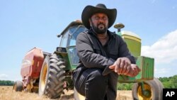 Farmer John Boyd Jr., poses for a portrait during a break from bailing hay at his farm in Boydton, Va., May 27, 2021. 