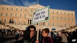 Demonstran pro Uni Eropa memegang dalam protes di depan parlemen di Athena, Yunani (18/6). (AP/Yorgos Karahalis)