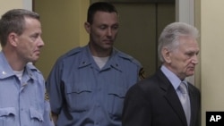 Flanked by UN security guards, Momcilo Perisic, the former chief of staff of the Yugoslav army, right, enters the court room of the Yugoslav War Crimes Tribunal in The Hague, to hear the verdict of the court, September 6, 2011.