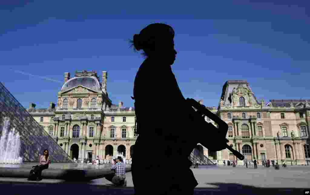 Binh sĩ đi tuần tra qua sân của bảo tàng Louvre ở Paris. Pháp đang xem xét việc mở rộng các cuộc không kích của mình sang Syria và tăng cường an ninh ở các nơi công cộng sau vụ con tin người Pháp bị chặt đầu. 