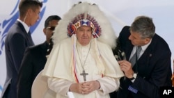 Pope Francis wears a headdress that was gifted to him during a visit with Indigenous peoples at Maskwaci, the former Ermineskin Residential School, Monday, July 25, 2022, in Maskwacis, Alberta. (AP Photo/Eric Gay)