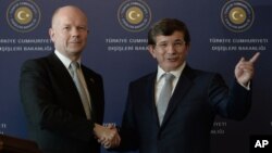 British Foreign Secretary William Hague, left, and his Turkish counterpart Ahmet Davutoglu shake hands after a news conference in Istanbul, Turkey, Nov. 20, 2013.