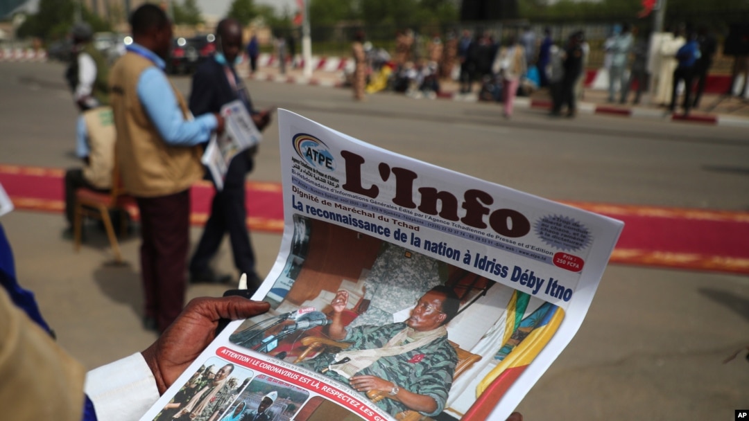 A journalist reads a local newspaper bearing the late Chadian president Idriss Deby on the front page, during the state funeral for Deby in N'Djamena, Chad, April 23, 2021. 