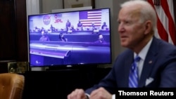 El presidente Joe Biden, en primer plano, desenfocado, conversa con los auténticos protagonistas de la jornada, el equipo del Laboratorio de Propulsión a Chorro de la NASA, desde la Casa Blanca, el 4 de marzo de 2021.