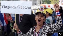 A Thai anti-government protester holds a placard and chants slogans during a rally at Victory Monument intersection, Jan. 21, 2014 in Bangkok, Thailand. 