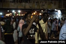 A young man drinks juice to hydrate himself on the first night of Ramadan after iftar on May 6, 2019, at the sit-in in Khartoum, Sudan.