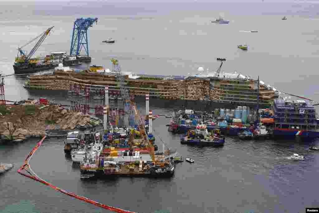 The damaged side of the capsized cruise liner Costa Concordia is visible after the ship was righted outside Giglio harbor, Italy, Sept. 17, 2013. 