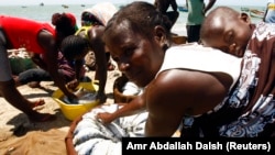 Uma mulher compra peixe seco no Casseque, Benguela. Angola