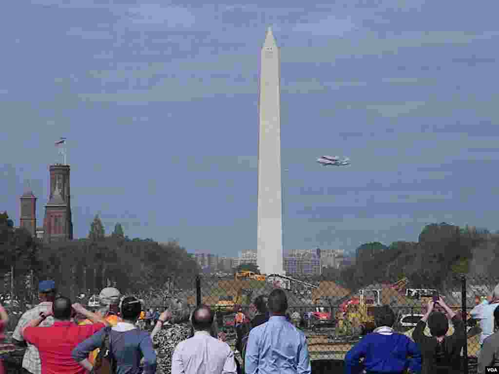 Residentes y turistas asisten al hist&oacute;rico momento cuando el Discovery vuela sobre la Alameda Nacional con el Monumento a Washington como testigo.
