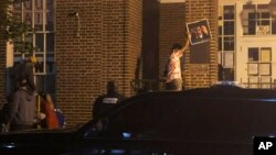 People remove posters from the front entrance of the Venezuelan Embassy in Washington on May 13, 2019.