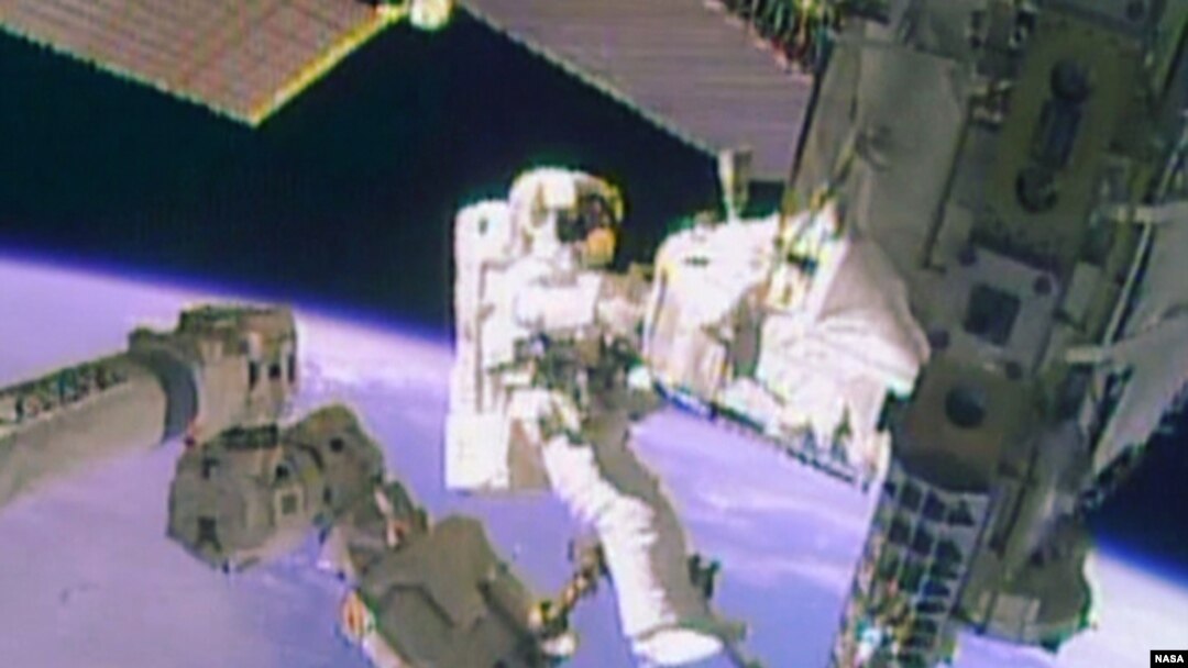 FILE - Astronaut Mike Hopkins works outside the International Space Station during a spacewalk, December 24, 2013, in this still image taken from video courtesy of NASA. Two NASA astronauts floated outside the International Space Station on Tuesday for a second 