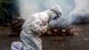 FILE - A woman breaks down as she prays before the cremation of a relative who died of COVID-19 in Gauhati, India, July 2, 2021. India crossed the grim milestone of more than 400,000 people lost to the coronavirus. 