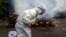 FILE - A woman breaks down as she prays before the cremation of a relative who died of COVID-19 in Gauhati, India, July 2, 2021. India crossed the grim milestone of more than 400,000 people lost to the coronavirus. 