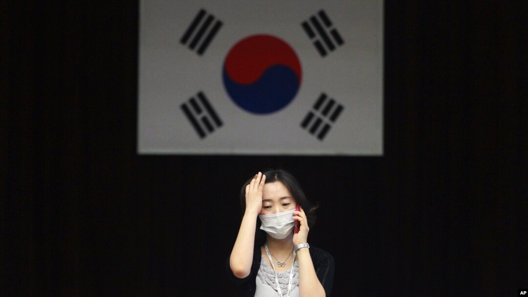 Seorang pekerja di distrik perkantoran Dongdaemun, Seoul, Korea Selatan mengenakan masker untuk tindakan pencegahan penularan virus MERS (Foto: dok).