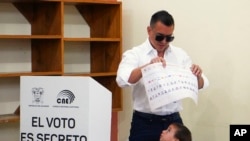 President Daniel Noboa, who is running for reelection, holds up his ballot before voting in the presidential election in Olon, Ecuador, Feb. 9, 2025.