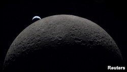 FILE PHOTO: A view of Earth, partially hidden by the Moon, photographed through the Orion spacecraft window