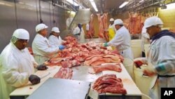 FILE - Workers cut pork at Park Packing, one of the Chicago's few remaining slaughterhouses, in Chicago, Illinois, July 18, 2015.