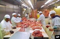 2015年7月18日芝加哥屠宰场工人切猪肉。