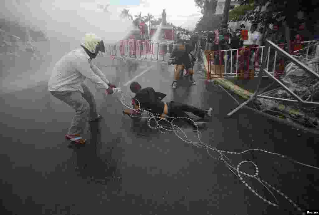 Police officers use water cannons during clashes with protesters near the Royal Palace in Phnom Penh, Sept. 15, 2013. 