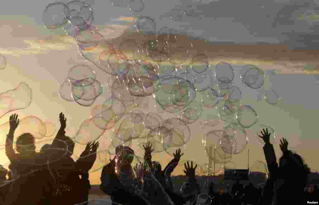 Children play with soap bubbles on the Promenade des Anglais in Nice, France.