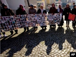 FILE - Members of the Srebrenica Women Union hold photographs of the 1995 Srebrenica massacre dead and missing in Tuzla, Bosnia, Nov. 11, 2017.