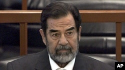 FILE - In this Dec. 6, 2006 file photo, former Iraq leader Saddam Hussein sits in court in Baghdad, Iraq, during the "Anfal" trial against him.