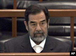 FILE - In this Dec. 6, 2006 file photo, former Iraq leader Saddam Hussein sits in court in Baghdad, Iraq, during the "Anfal" trial against him.