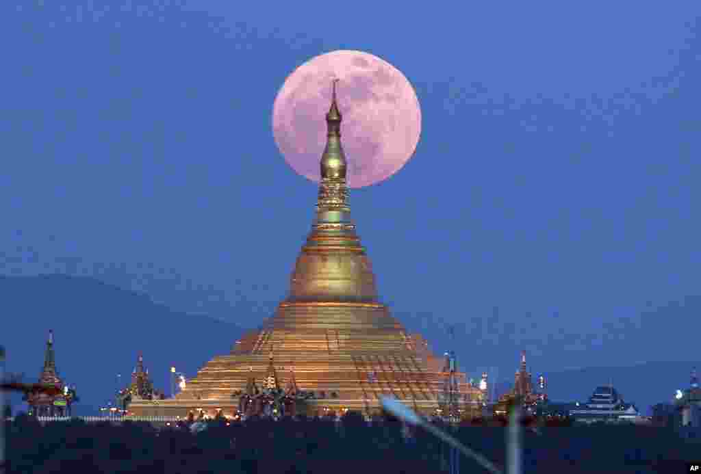The moon rises behind the Uppatasanti Pagoda seen in Naypyitaw, Myanmar. The Dec. 3 full moon is the first of three consecutive supermoons. The two will occur on Jan. 1 and Jan. 31, 2018.