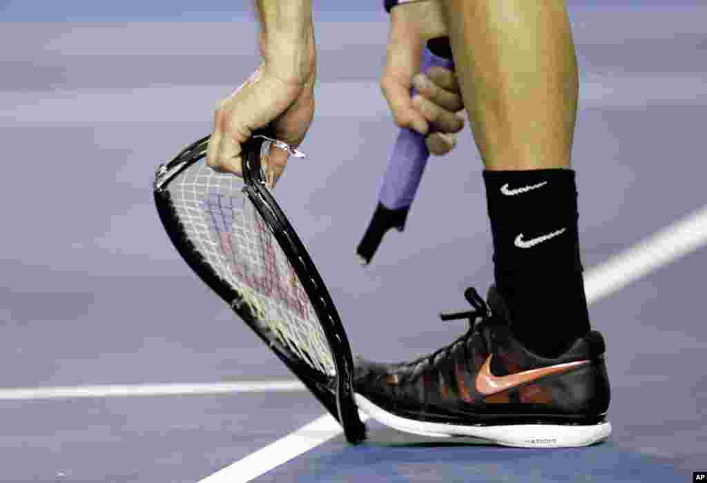 Grigor Dimitrov of Bulgaria breaks his racket as he plays Andy Murray of Britain during their fourth round match at the Australian Open tennis championship in Melbourne.