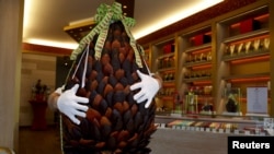 British pastry cook Michael Lewis-Anderson holds a sixty-kilogram giant chocolate egg with candied orange peel in the form of an artichoke at a Wittamer chocolate boutique ahead of the Easter weekend in Brussels, April 3, 2015.