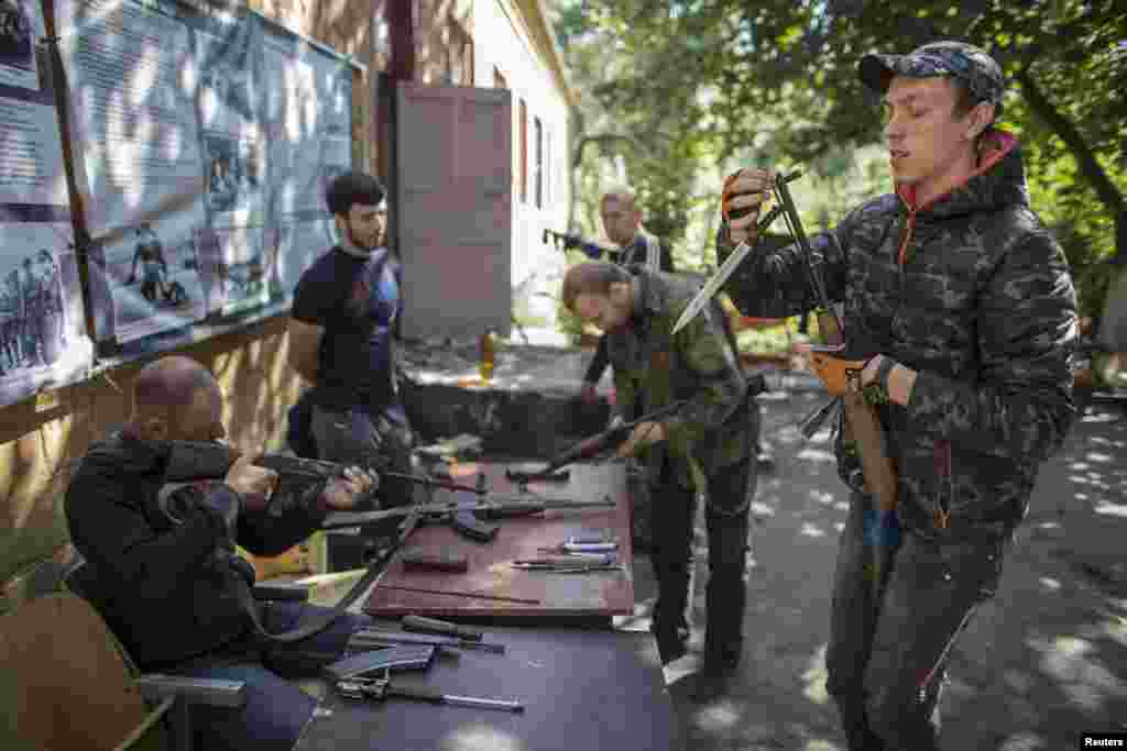 Pro-Russian rebels check their rifles inside the Vostok battalion base in Donetsk, eastern Ukraine, Sept. 17, 2014.