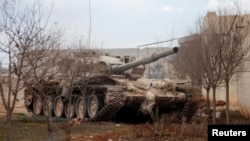 FILE - A Syrian army tank is seen on the outskirts of the northern city of Aleppo, Syria, Feb. 27, 2014. Syrian government troops, backed by Russian forces and Iran-supported Shia militias, are said to be preparing to take the rebel toehold.