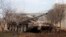 FILE - A Syrian army tank is seen on the outskirts of the northern city of Aleppo, Syria, Feb. 27, 2014. Syrian government troops, backed by Russian forces and Iran-supported Shia militias, are said to be preparing to take the rebel toehold.